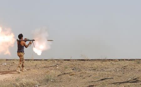 An Iraqi Shi'ite fighter fires a rocket-propelled grenade (RPG) during clashes with Islamic State militants on the outskirt of Falluja, Iraq. REUTERS/Stringer