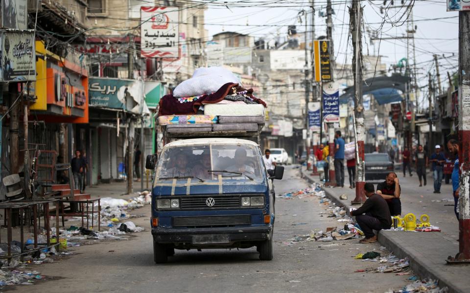 Palestinians transport their belongings on the back of a van as they flee Rafah