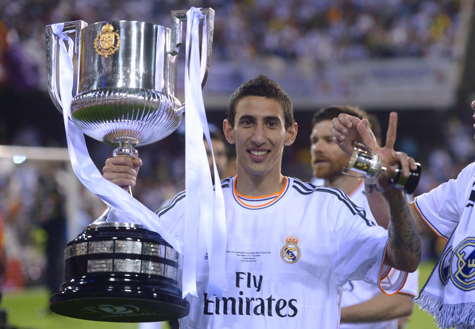 Real's Angel Di Maria poses with the trophy at the end of the final of the Copa del Rey between FC Barcelona and Real Madrid at the Mestalla stadium in Valencia, Spain, Wednesday, April 16, 2014. Real defeated Barcelona 2-1. (AP Photo/Manu Fernandez)