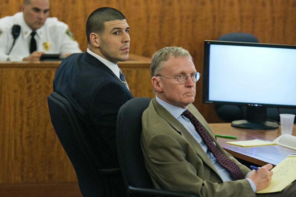 Former New England Patriots star Aaron Hernandez (L) listens to testimony with defense attorney Charles Rankin during his murder trial at the Bristol County Superior Court in Fall River, Massachusetts, February 18, 2015. Hernandez is on trial on charges of murdering semi-professional football player Odin Lloyd on June 17, 2013, the first of two murder trials he will face this year. REUTERS/Dominick Reuter/Pool (UNITED STATES - Tags: CRIME LAW SPORT FOOTBALL)