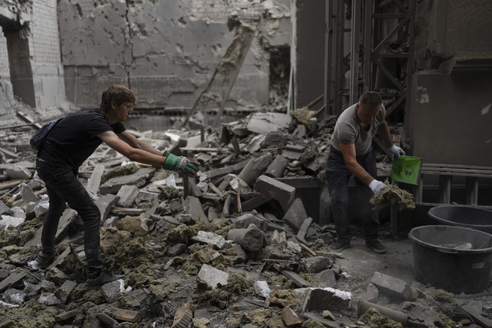 Two men clean up inside the Odesa Transfiguration Cathedral after it was heavily damaged in Russian missile attacks in Odesa, Ukraine, Sunday, July 23, 2023. (AP Photo/Jae C. Hong)