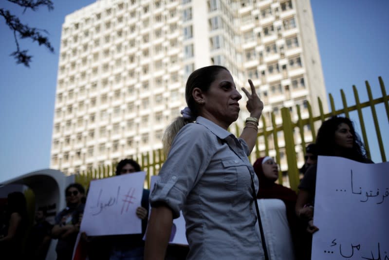 A woman gestures towards demonstrators protesting outside the state owned electricity company during ongoing anti-government protests in Beirut