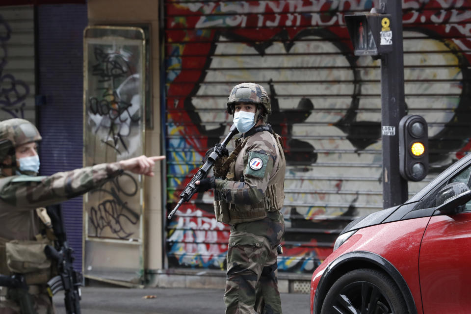 French soldiers patrol after four people have been wounded in a knife attack near the former offices of satirical newspaper Charlie Hebdo, Friday Sept. 25, 2020 in Paris. A police official said officers are "actively hunting" for the perpetrators and have cordoned off the area including the former Charlie Hebdo offices after a suspect package was noticed nearby. Islamic extremists attacked the offices in 2015, killing 12 people. (AP Photo/Thibault Camus)