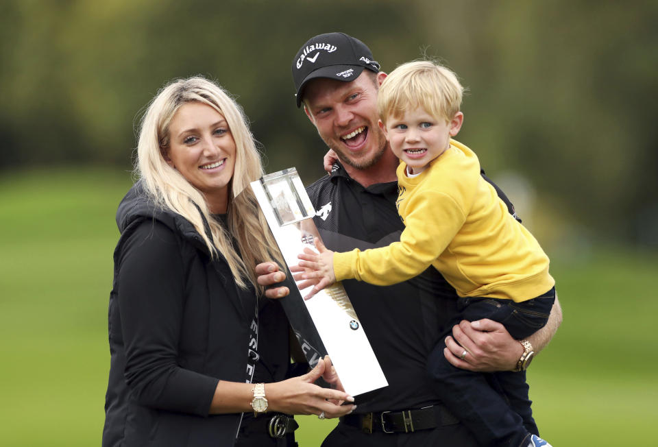 England's Danny Willett, his wife Nicole and son Zachariah James pose with the trophy after winning the PGA Championship at Wentworth Golf Club, Wentworth, England, Sunday Sept. 22, 2019. (Bradley Collyer/PA via AP)
