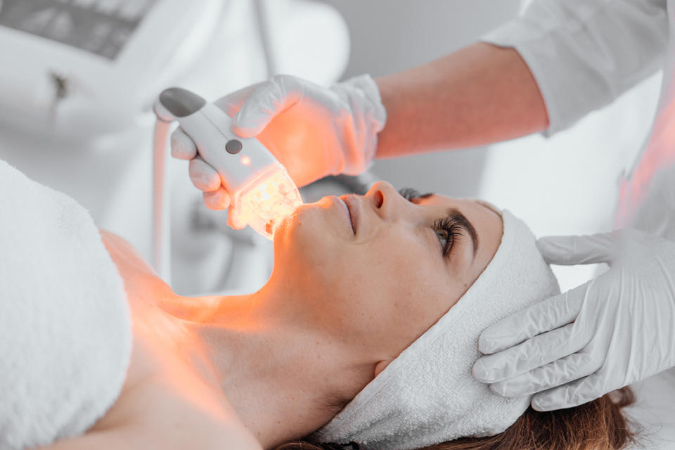 Woman getting red light therapy done on face for broken blood vessels on face