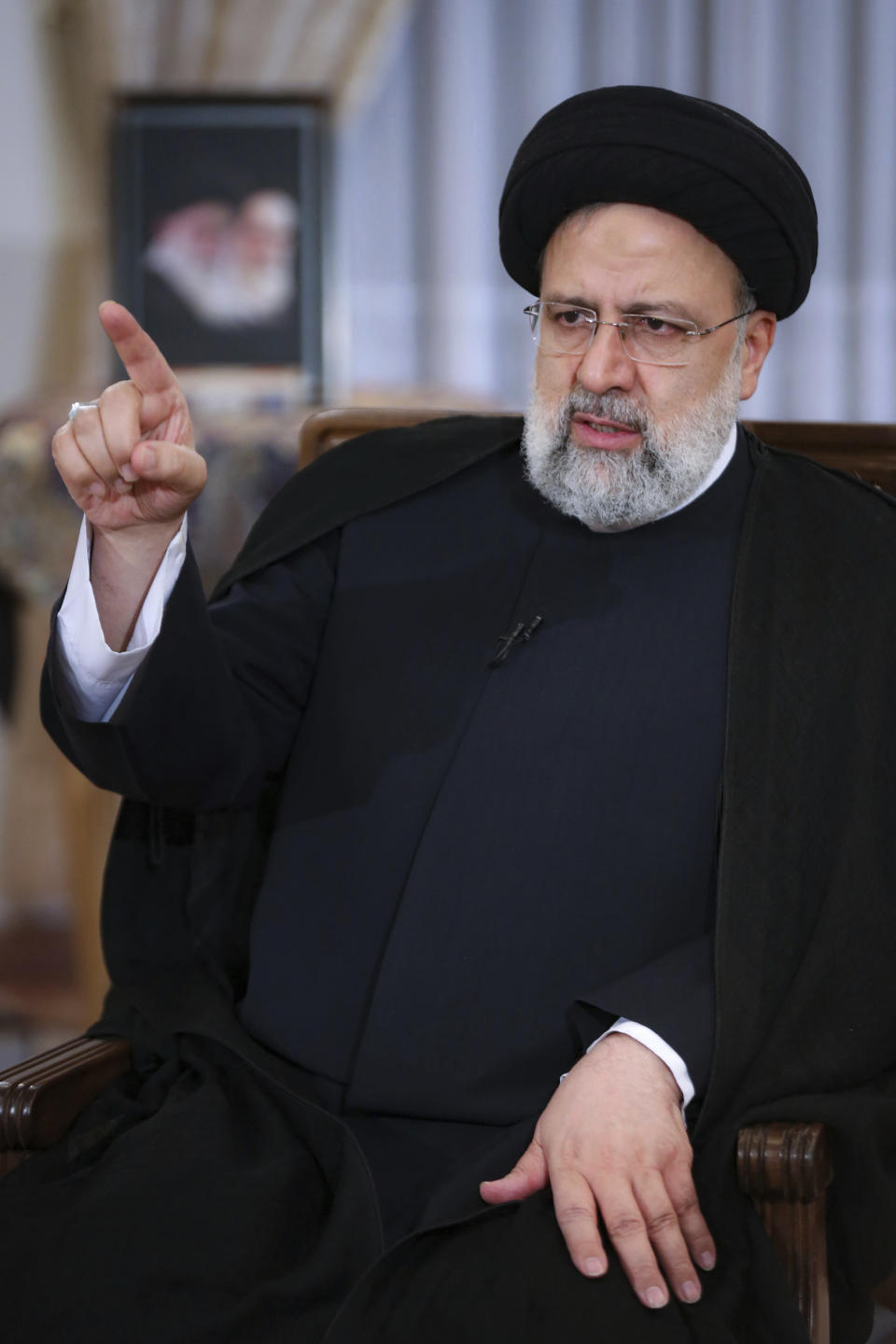 In this photo released by the official website of the office of the Iranian Presidency, President Ebrahim Raisi speaks in a live interview with state-run TV, at the presidency office in Tehran, Iran, Monday, May 9, 2022. Raisi said the country is exporting twice as much oil as when he took office in August, despite heavy sanctions on oil exports imposed by the U.S. (Iranian Presidency Office via AP)