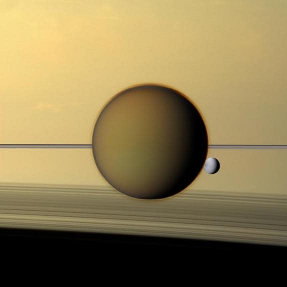 Studying areas such as Titan, a moon of Saturn (foreground) can give researchers ideas about how chemistry eventually created life.