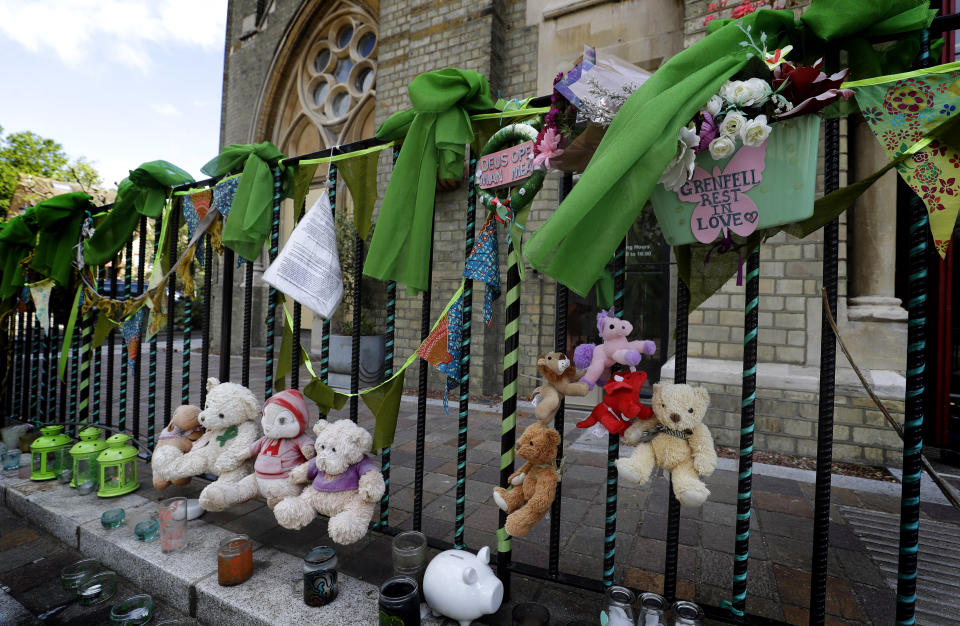 Tributes are tied to the railings outside Notting Hill Methodist Church near Grenfell Tower in London, Sunday, June 14, 2020. Britain is marking the third anniversary of the Grenfell Tower fire with a virtual church service to remember the 72 people who died in the blaze. Sunday marks three years since a small kitchen fire in the west London public-housing block turned into the worst domestic blaze in the country since World War II. (AP Photo/Kirsty Wigglesworth)