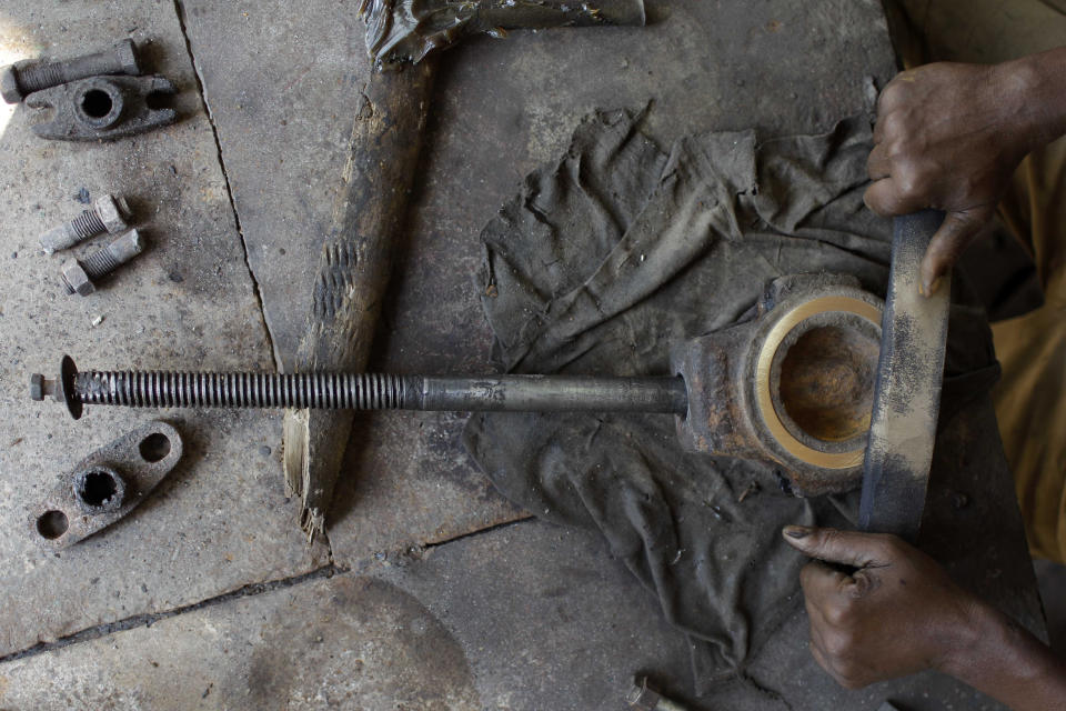 In this Sept. 8, 2012 photo, Vicente Diaz, 60, repairs a valve that regulates the passage of the cane juice in sugar processing plant "Brasil" in Jaronu, Cuba. The Brasil sugar plant, launched in 1921, is getting a makeover and is expected to be ready in time for the upcoming annual harvest and start milling cane by February. (AP Photo/Franklin Reyes)