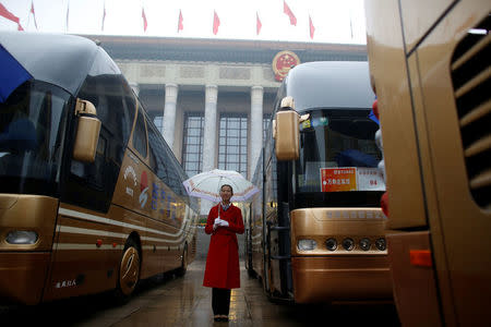 A hostess waits for the arrival of delegates outside the Great Hall of the People before the opening of the 19th National Congress of the Communist Party of China in Beijing, China October 18, 2017. REUTERS/Thomas Peter