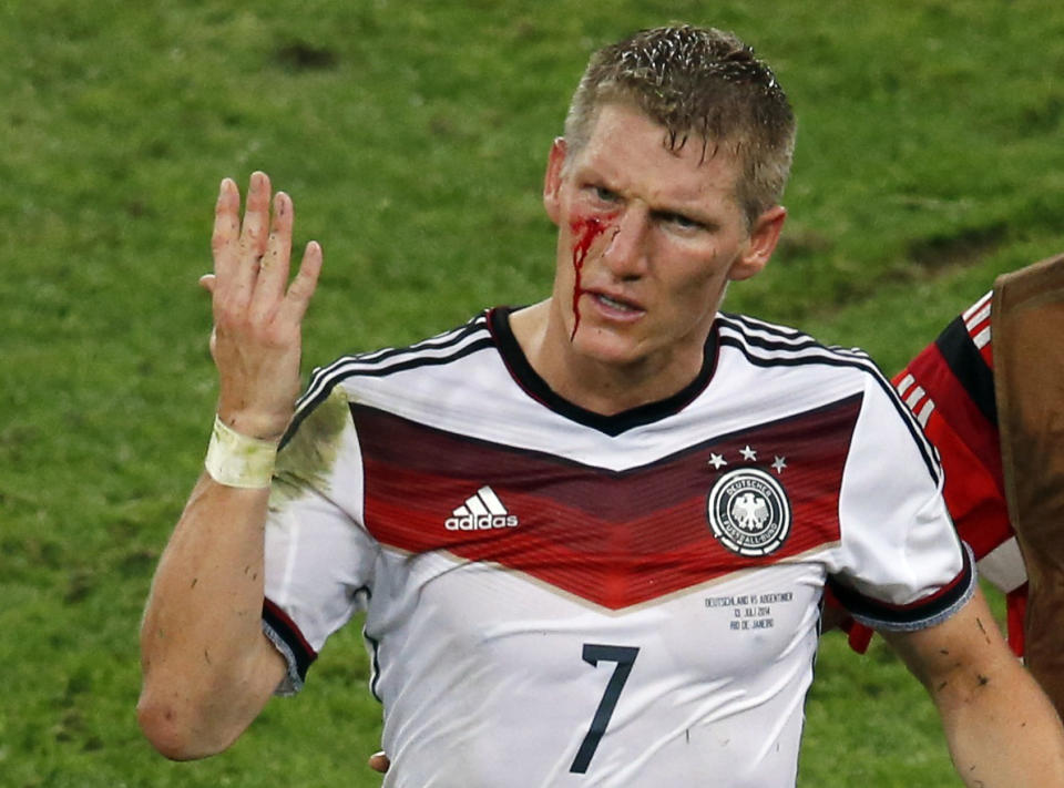 Germany's Bastian Schweinsteiger reacts as blood flows down his face after he was fouled during their 2014 World Cup final against Argentina at the Maracana stadium in Rio de Janeiro July 13, 2014. REUTERS/Paulo Whitaker (BRAZIL - Tags: SOCCER SPORT WORLD CUP)