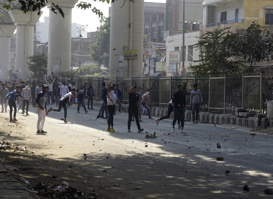 A group of protestors clash with another group in New Delhi, India, Monday, Feb. 24, 2020. Indian paramilitary troops used tear gas and smoke grenades to disperse a crowd of clashing protesters in New Delhi on Monday as violence broke out over a new citizenship law just ahead of U.S. President Donald Trump’s visit to the city. (AP Photo/Dinesh Joshi)