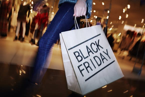 A person carries a shopping bag with the words Black Friday on it.