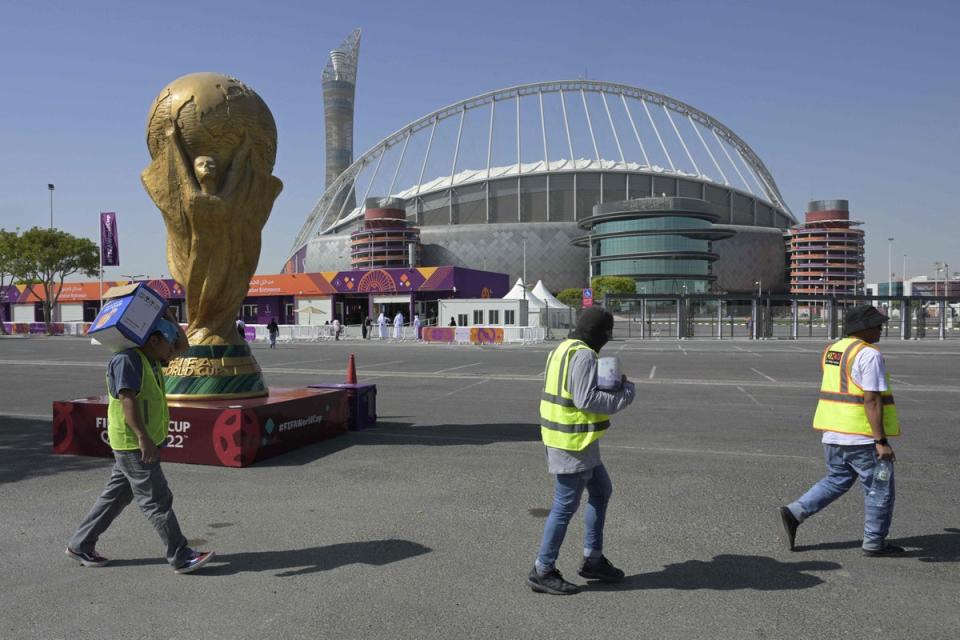 Workers walk past the Khalifa International Stadium (AFP via Getty Images)