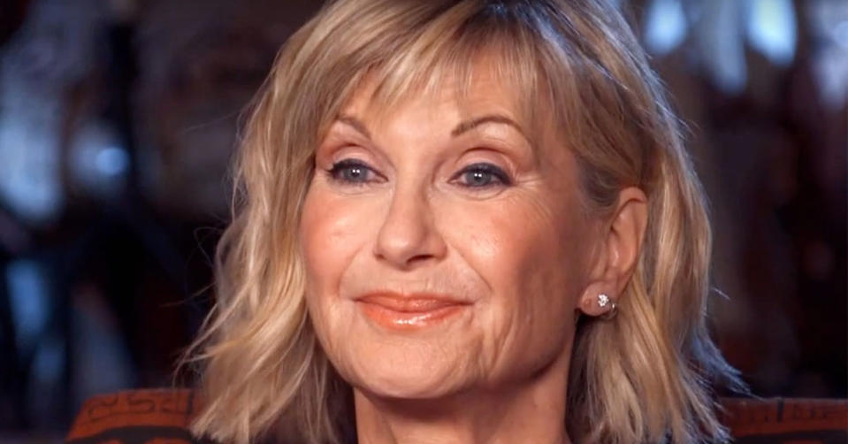 Olivia Newton-John smiles at an interviewer