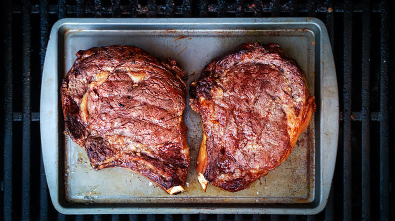 Steaks resting on baking sheet 