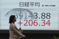 A person walks in front of an electronic stock board showing Japan's Nikkei index at a securities firm, Wednesday, Oct. 9, 2024, in Tokyo. (AP Photo/Eugene Hoshiko)