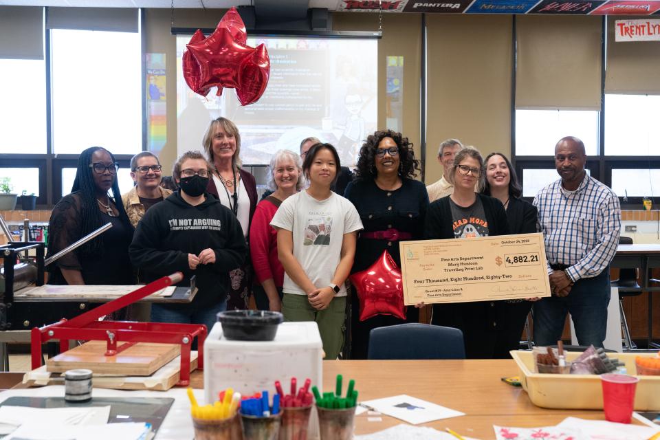 Topeka High art teacher Amy Cline poses with a grant check for $4,882.21, given to her by the Topeka Public School Foundation on Tuesday morning.