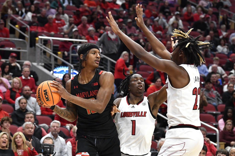 Maryland forward Julian Reese looks for help form the defense of Louisville guard Mike James (1) and forward Kamari Lands during the first half of an NCAA college basketball game in Louisville, Ky., Tuesday, Nov. 29, 2022. (AP Photo/Timothy D. Easley)