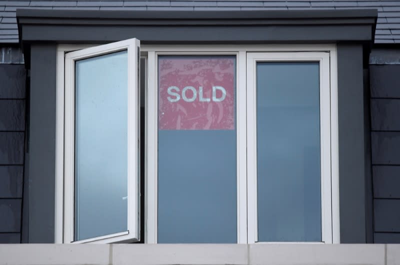 FILE PHOTO: Property sold signs are seen on windows of a group of newly built houses in west London