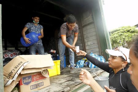 Volunteers offer food and water to people in Pedernales, after an earthquake struck off Ecuador's Pacific coast, April 21, 2016. REUTERS/Guillermo Granja