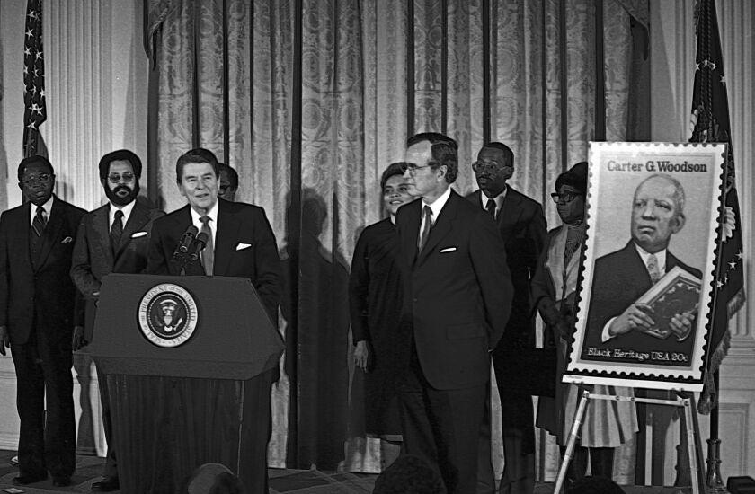 President Ronald Reagan unveils postage stamp of Carter Woodson (father of black history) at a White House Ceremony marking the observance of National Afro-American (Black) History Month, Washington DC, February 2, 1984. (Photo by Mark Reinstein/Corbis via Getty Images)