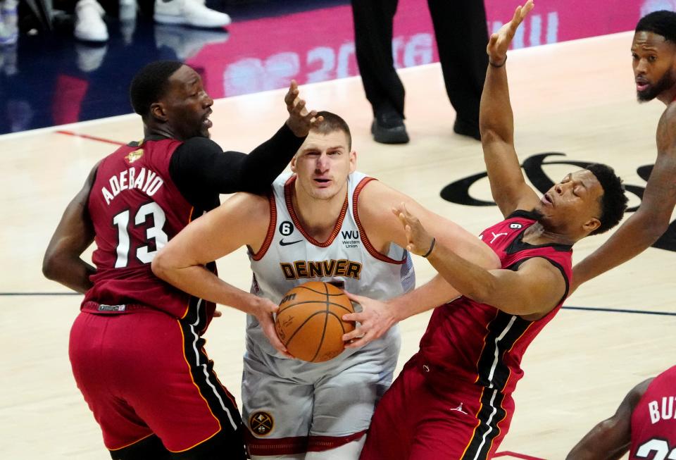 Denver Nuggets center Nikola Jokic (15) drives against Miami Heat center Bam Adebayo (13) and guard Kyle Lowry (7) during Game 5 of the NBA Finals.