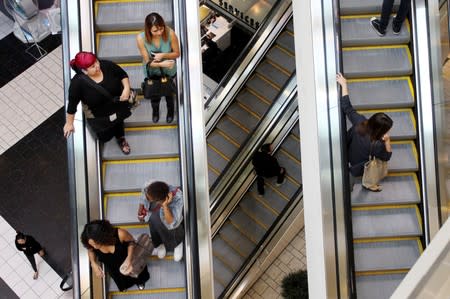 Shoppers ride escalators at the Beverly Center mall in Los Angeles