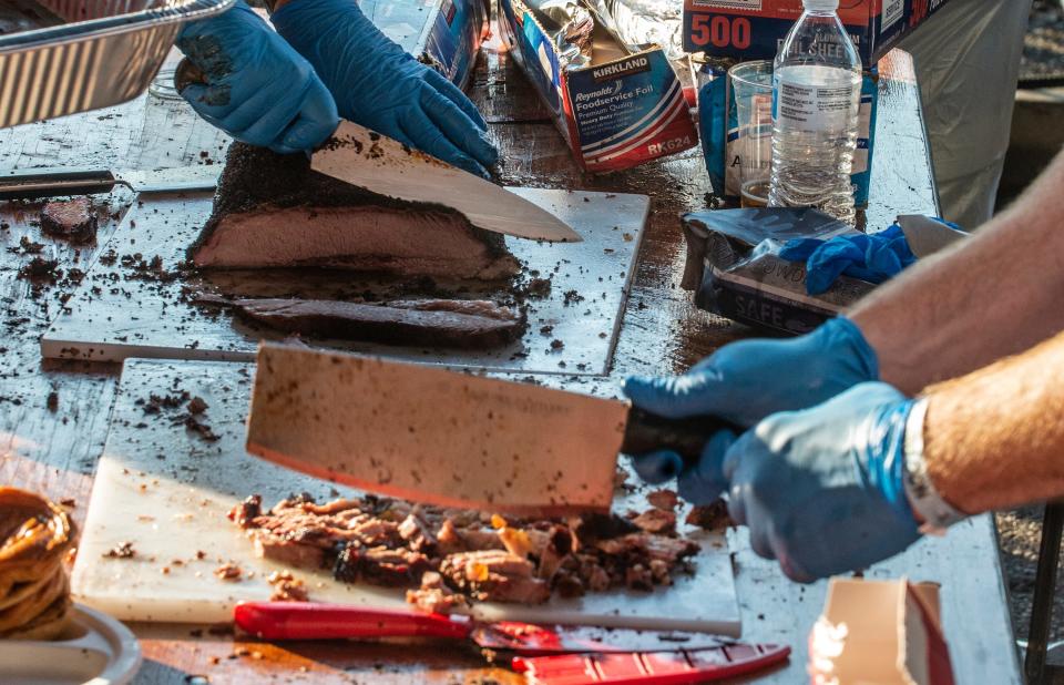 The Druids Charity Club slices and chops barbecue during Hog Days of Summer BBQ and Music Festival in downtown Montgomery at the Union Station Train Shed.