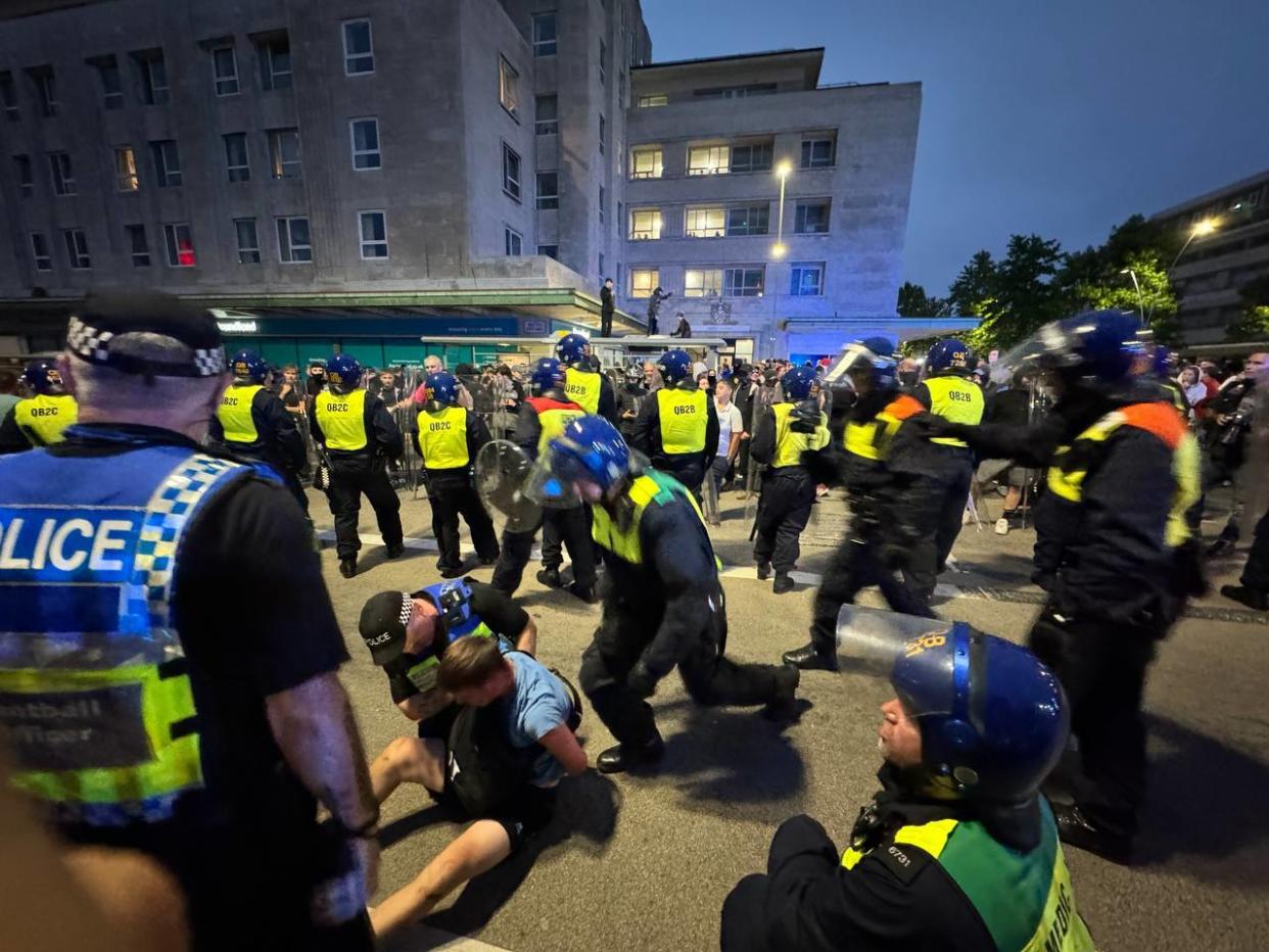 PLYMOUTH, UNITED KINGDOM - AUGUST 05:Police officers detain some far-right protesters after they tried to cross to the side of the opposing group in Plymouth, United Kingdom on August 05, 2024. (Photo by Behlul Cetinkaya/Anadolu via Getty Images)