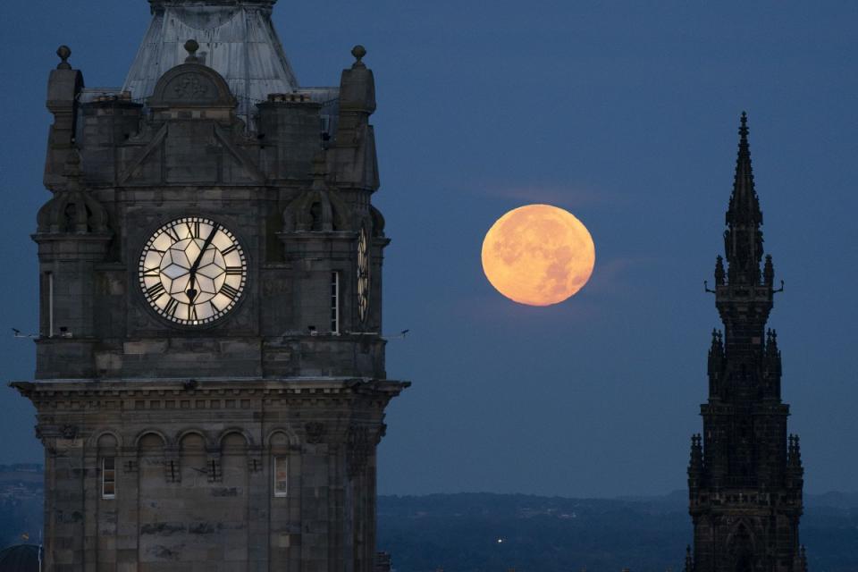 The super blue moon sets between the Balmoral Clock and the Scott Monument in Edinburgh on Aug. 31, 2023.<span class="copyright">Jane Barlow—PA Images/Getty Images</span>