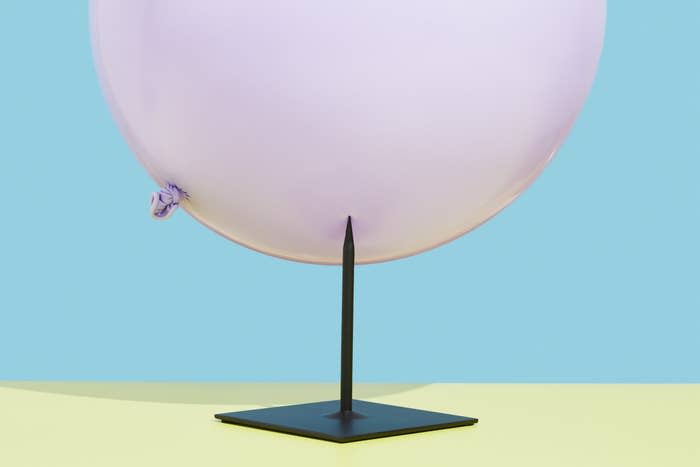 a balloon about to be punctured by a nail