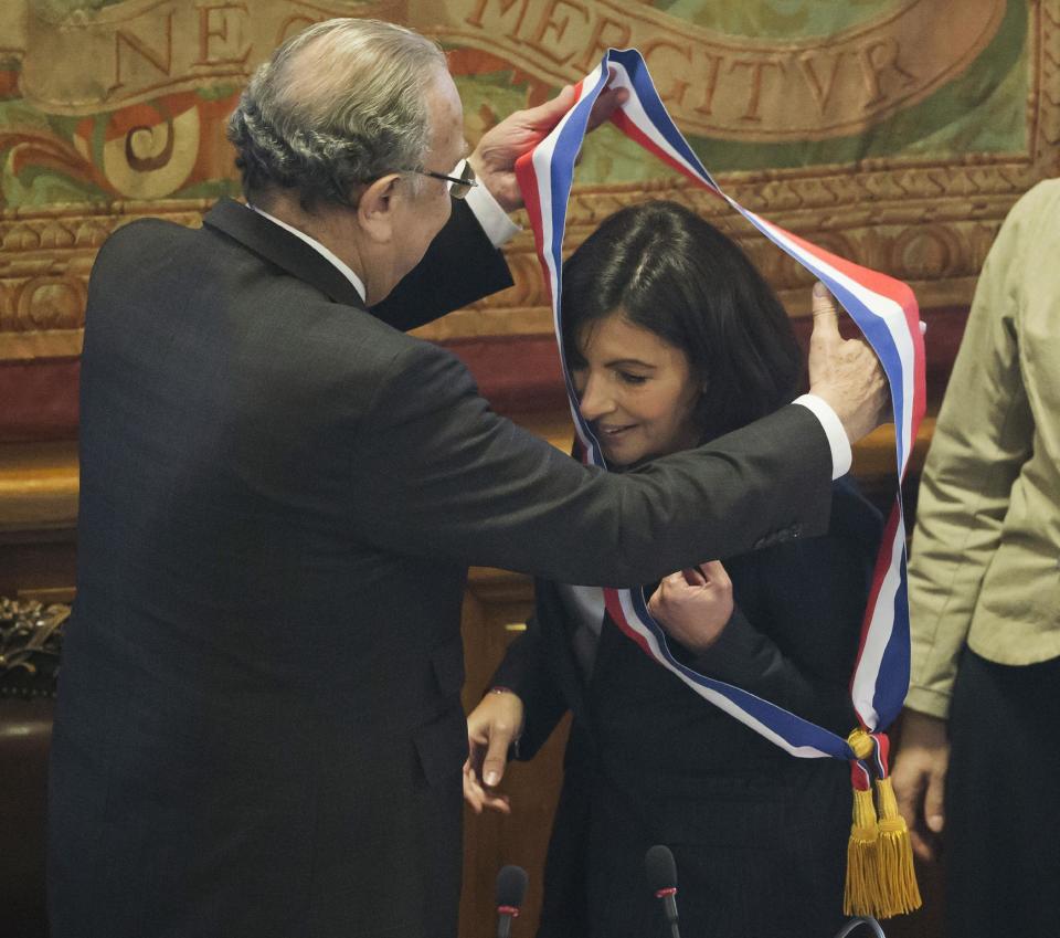 The new mayor of Paris Anne Hidalgo, accepts the mayoral sash in the color of the French Republic, after her election, in Paris, Saturday, April 5, 2014. The first woman mayor of Paris has taken office, hailing a “great advance for all women” and saying she feels the weight of responsibility in her new job. (AP Photo/Michel Euler)