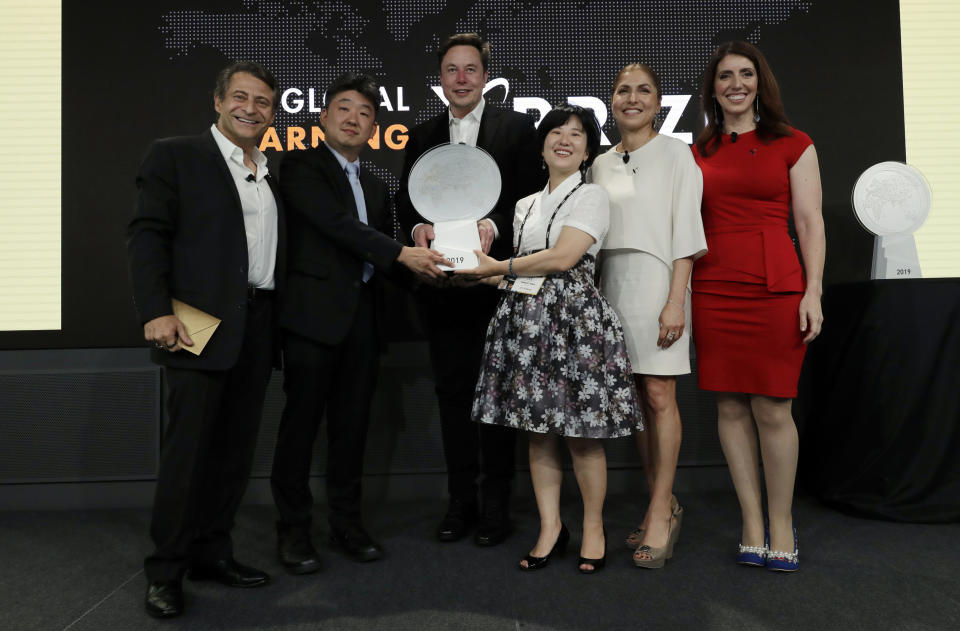 Kitkit School CEO Sooinn Lee, third from right, and Chief Engineer, Gunho Lee, second from left, receive the XPRIZE for Children's Literacy from XPRIZE Founder and Executive Chairman, Peter Diamandis, far left, Telsa CEO Elon Musk, third from left, XPRIZE CEO Anousheh Ansari, second from right, and Executive Director Emily Church, far right, Wednesday, May 15, 2019, in Los Angeles. The Berkeley-based Kitkit School and London's onebillion educational nonprofit were declared co-winners of the XPRIZE For Global Learning at a presentation Wednesday night. (AP Photo/Marcio Jose Sanchez)