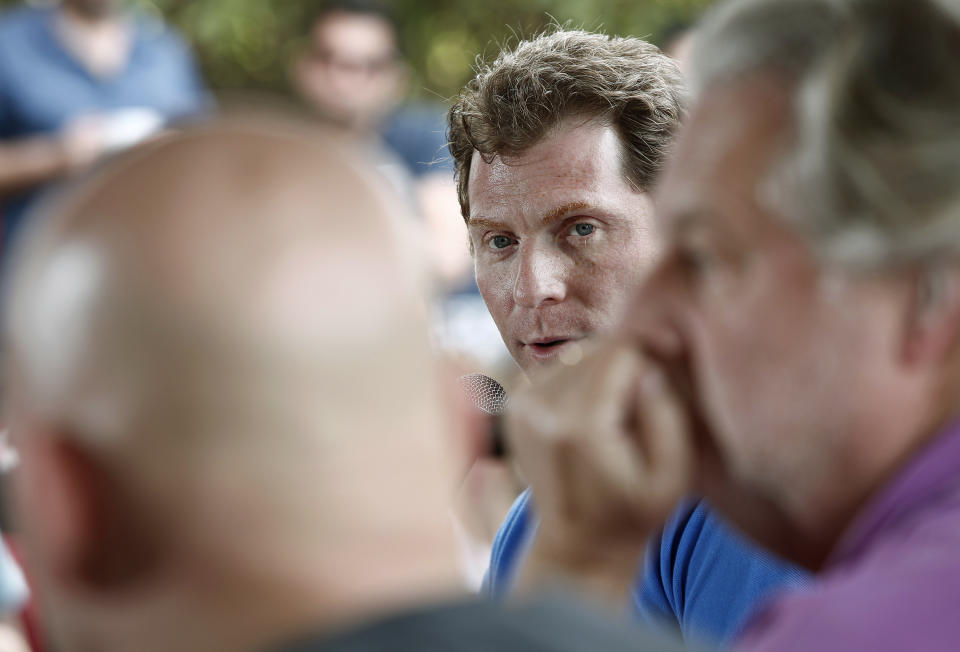 Celebrity chef Bobby Flay moderates a panel discussion about the experience of competing on TV cooking competitions, Saturday, Feb. 25, 2012 in Miami. Flay is framed between Michael Symon, left, and Jonathan Waxman. (AP Photo/Carlo Allegri)