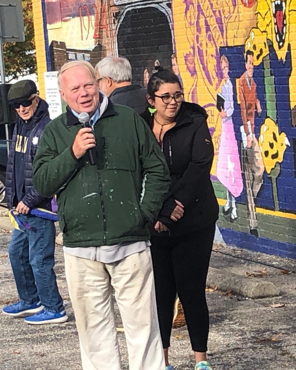 Artist Dave Blodgett speaks at the ribbon-cutting ceremony Oct. 28, 2023, that officially completed a new mural in honor of Riley High School, which celebrates its 100th anniversary in 2024.