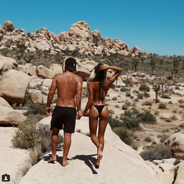 <p>The tanned-couple are seen holding hands walking through Joshua Tree National Park which is made up of rugged rock formations and stark desert landscapes, showing some flesh in their swimwear.</p>