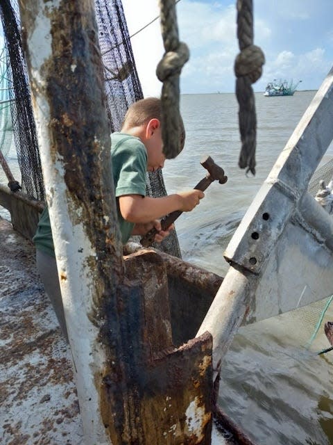 Trace Parfait looks at oil on the nets of the shrimp boat Corey Elena, owned by his cousin, Carl Parfait Jr., near Lake Barre, a few miles east of Cocodrie, on Tuesday, Aug. 9, 2022.