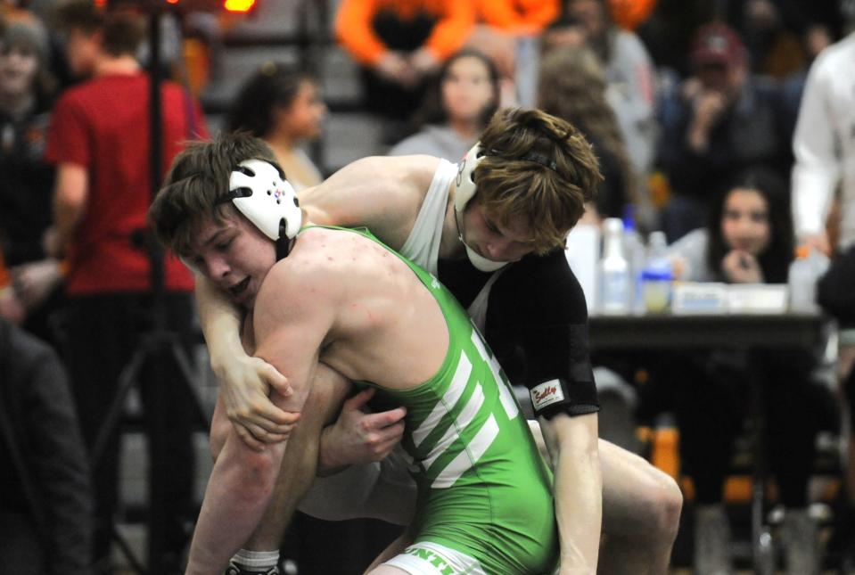 Huntington's Morgan Breniser (green) grapples with Westfall's Bryce Wickline in the 175-pound consolation finals at the Division III district tournament at Heath High School on March 2, 2024, in Heath, Ohio.
