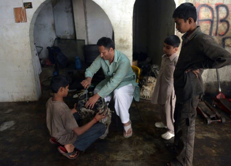 Blind mechanic Asif Patel works on a car engine at his workshop in Karachi