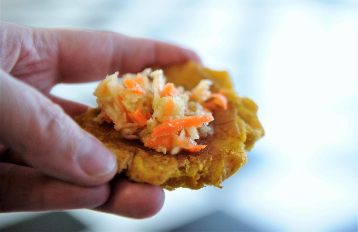 A fried plantain topped with spicy pikliz relish at Caribbean Cuisine on Kentucky Avenue.