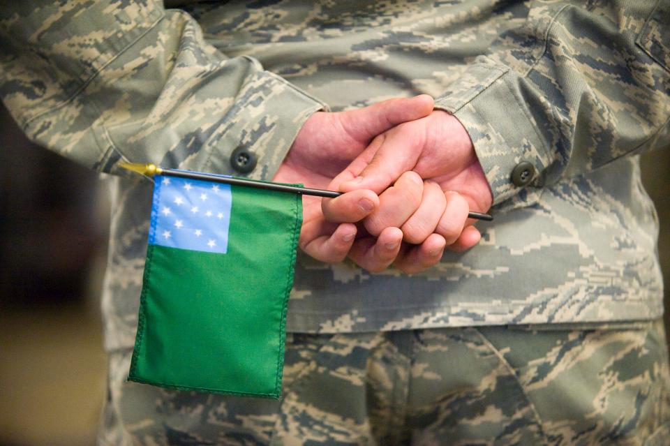 An airman holds a Green Mountain battle flag during a deployment ceremony in 2020.