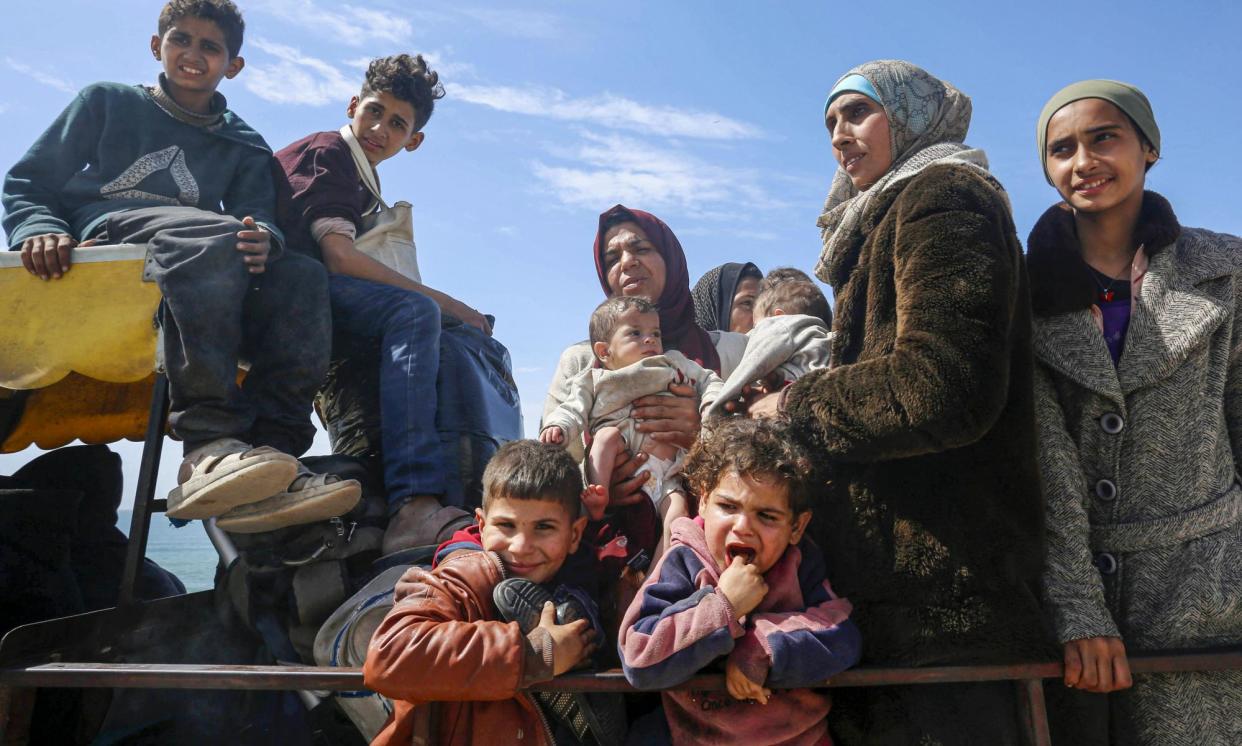 <span>Palestinian refugees displaced after Israeli attacks in Gaza crowd into the back of a pick-up truck on Thursday.</span><span>Photograph: Anadolu/Getty Images</span>