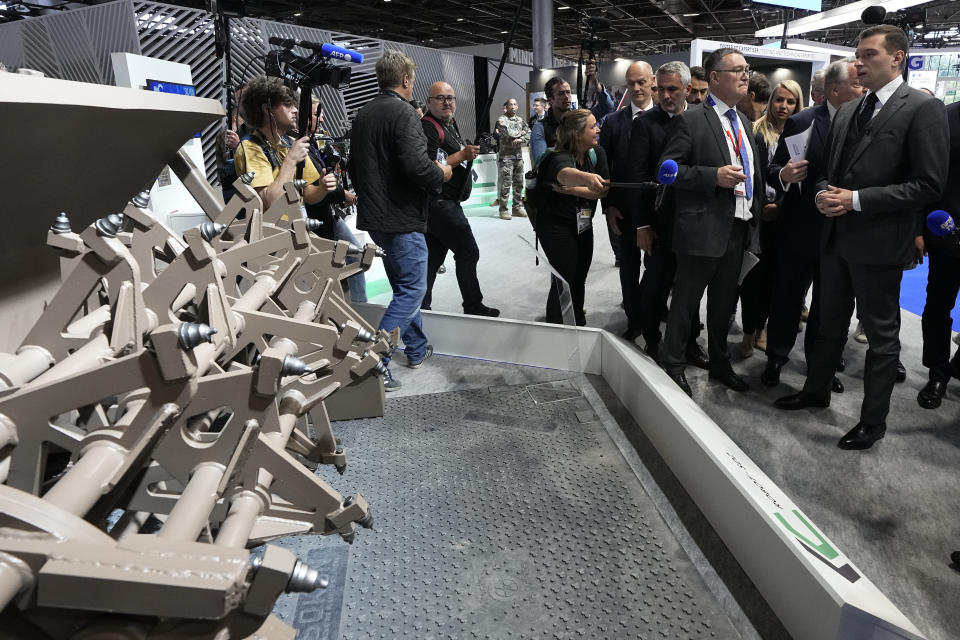 Jordan Bardella, right, president of the far-right National Front party, looks at son defining system at the Eurosatory Defense and Security exhibition, Wednesday, June 19, 2024 in Villepinte, north of Paris. Jordan Bardella, hoping to become France's prime minister, appealed Tuesday to voters to hand his party a clear majority after French President Emmanuel Macron's announcement on June 9 that he was dissolving France's National Assembly, parliament's lower house.( AP Photo/Michel Euler)