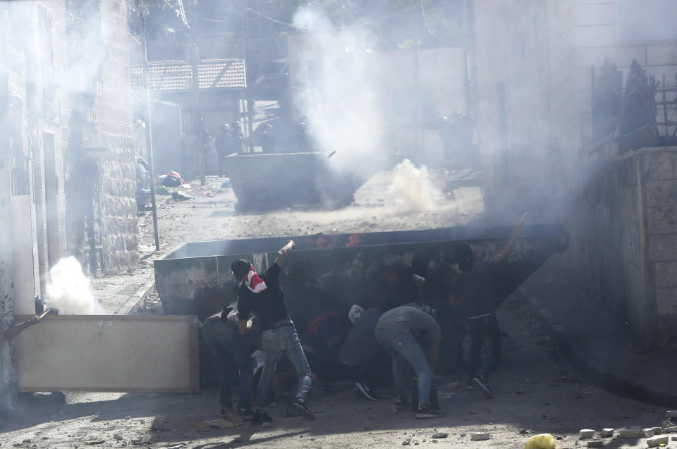 FILE - In this June 28, 2019 file photo, Palestinians clash with Israeli police in the Palestinian neighborhood of Issawiya in East Jerusalem, a day after a Palestinian was shot and killed by police during a protest in the same neighborhood. Nearly every day for the last nine months Israeli police have stormed into Palestinian neighborhood of Issawiya in east Jerusalem in a campaign they say is needed to maintain law and order. Rights groups say that in addition to searching houses and issuing fines, they have detained hundreds of people — some as young as 10, on suspicion of stone-throwing. (AP Photo/Mahmoud Illean, File)