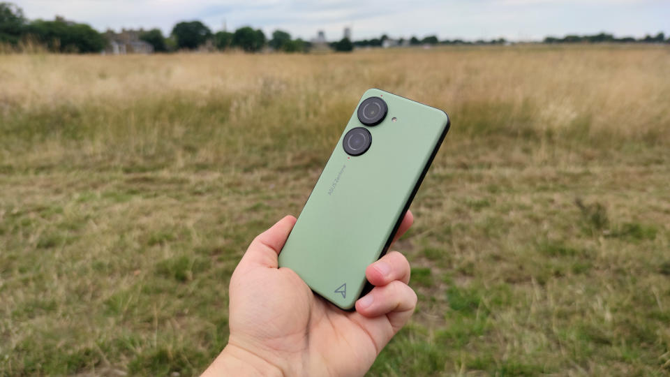 The Asus Zenfone 10 on a bench, with a field in the background