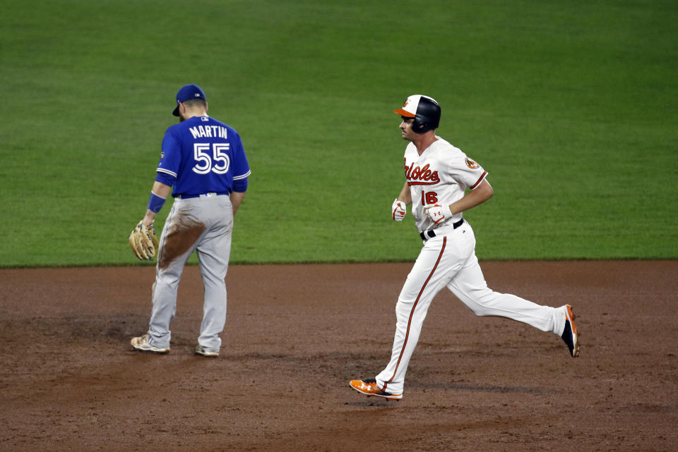 Baltimore Orioles' Trey Mancini, right, rounds the bases past Toronto Blue Jays third baseman Russell Martin after hitting a three-run home run in the sixth inning of a baseball game, Monday, Aug. 27, 2018, in Baltimore. (AP Photo/Patrick Semansky)