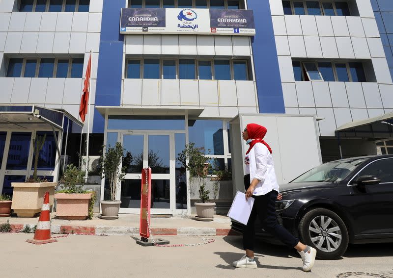 A woman walks past the building of the Islamist Ennahda party headquarters in Tunis