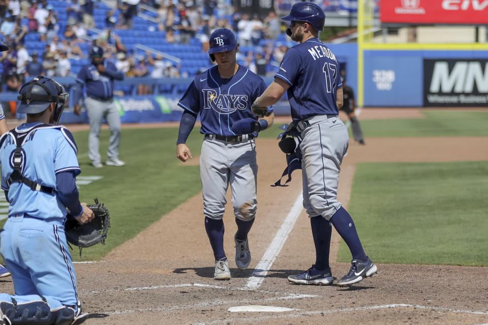 Tampa Bay Rays' Austin Meadows, right, celebrates as his walk scores Taylor Walls in front of Toronto Blue Jays catcher Danny Jansen during the ninth inning of a baseball game Sunday, May 23, 2021, in Dunedin, Fla. (AP Photo/Mike Carlson)