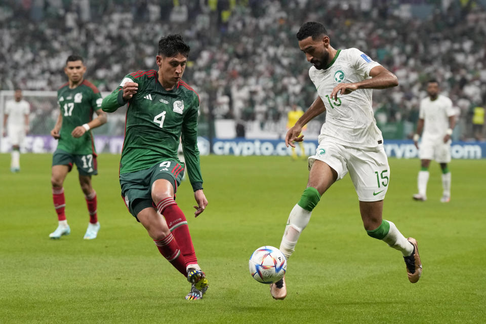 Saudi Arabia's Ali Al-Hassan, right, drives the ball past Mexico's Edson Alvarez during the World Cup group C soccer match between Saudi Arabia and Mexico, at the Lusail Stadium in Lusail, Qatar, Wednesday, Nov. 30, 2022. (AP Photo/Ricardo Mazalan)